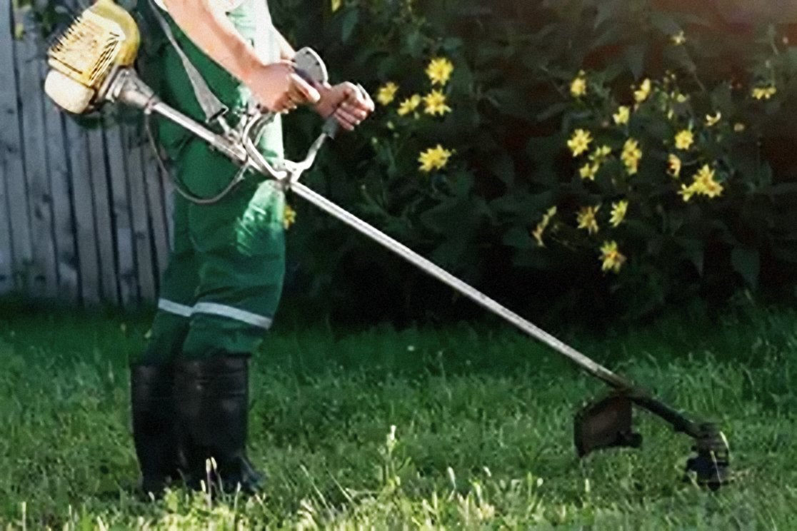 Corte de pasto con desbrozadora en un jardín
